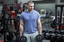 A man holding dumbbells in a gym. - Mike Harrington/Getty Images